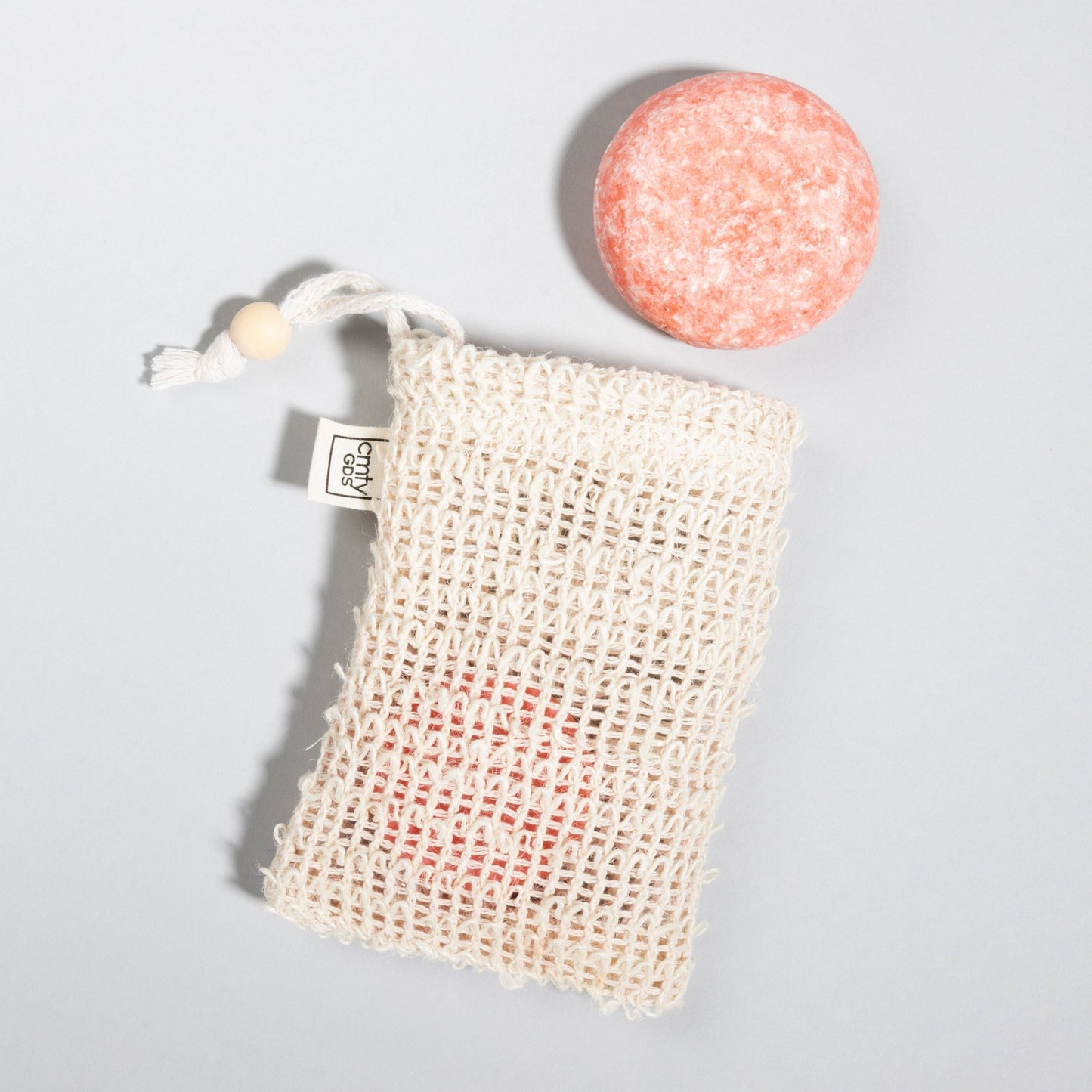 Sisal Shampoo Bar Saving Bag, by Community Goods, next to a Citrus Squeeze Shampoo Bar