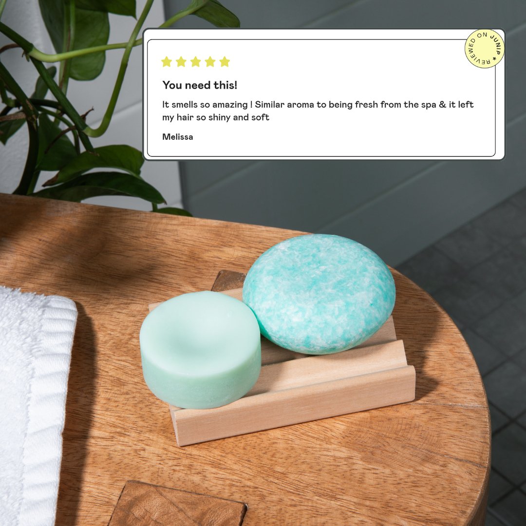 The best shampoo bar and conditioner bar set, by Community Goods, is shown in a modern bathroom next to a 5 star review saying it left her hair soft and shiny