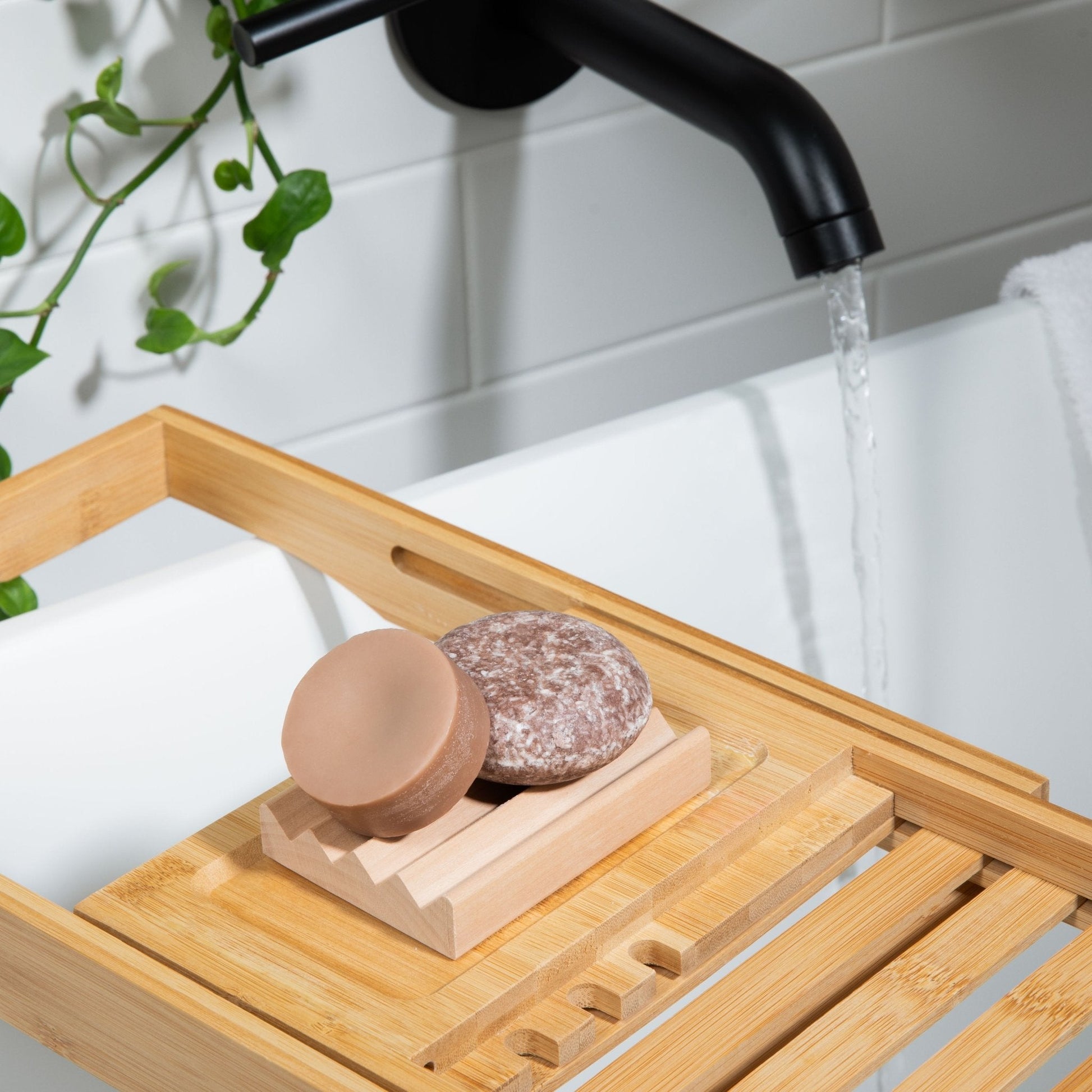 A natural shampoo bar and conditioner bar set is shown in a modern bathroom with natural décor. 